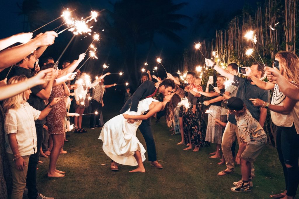 Loving Newlywed Couple Kissing among Wedding Guests