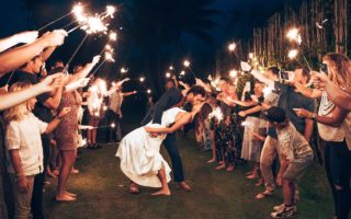 Loving Newlywed Couple Kissing among Wedding Guests