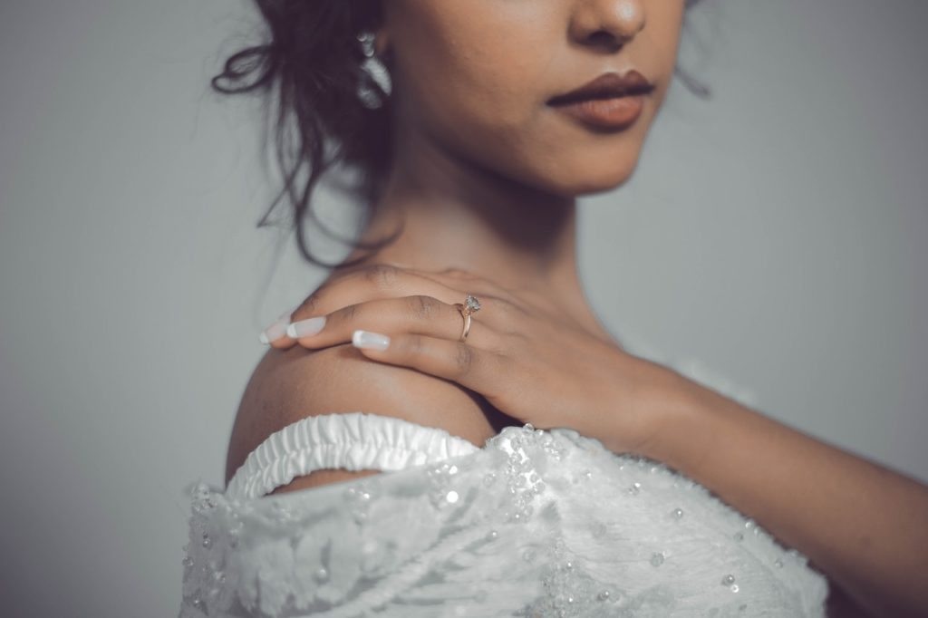 Woman Touching Her Shoulder Wearing Ring On Right Hand