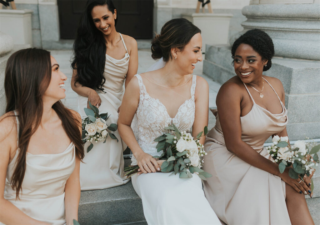 A beautiful bride is talking with her bridesmaids. They are waiting for the bridal party.