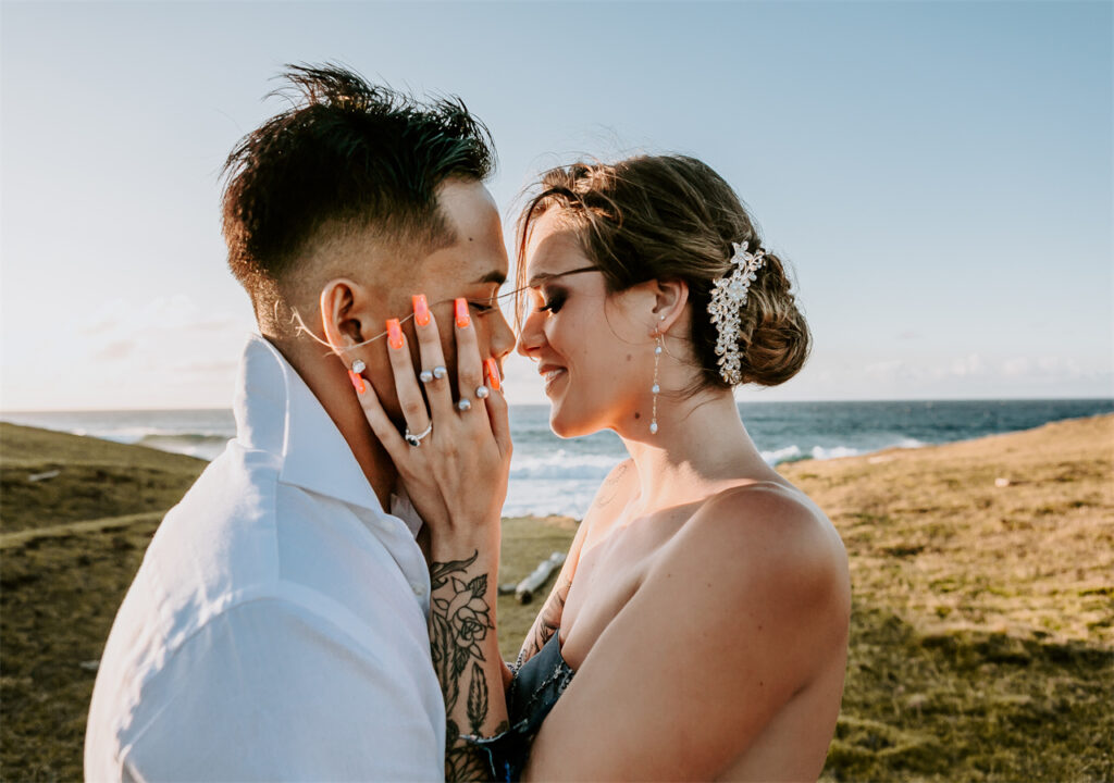 A couple are kissing under the warm sunlight. The bride is wearing a AW Bridal wedding dress.