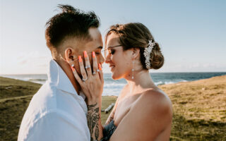 A couple are kissing under the warm sunlight. The bride is wearing a AW Bridal wedding dress.