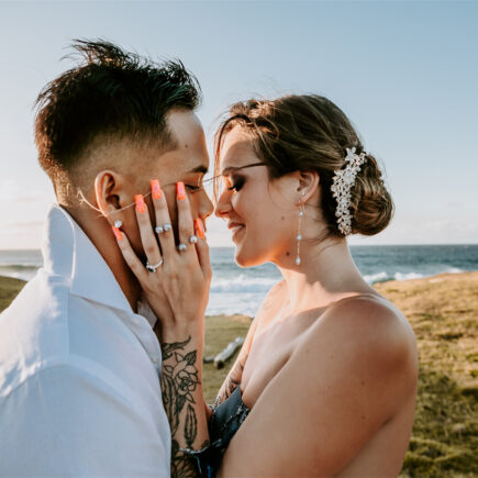 A couple are kissing under the warm sunlight. The bride is wearing a AW Bridal wedding dress.