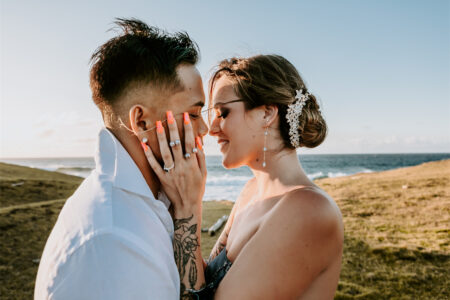 A couple are kissing under the warm sunlight. The bride is wearing a AW Bridal wedding dress.