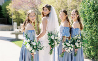 A group of beautiful girls are smiling brightly in the sun, looking forward to a wedding party.