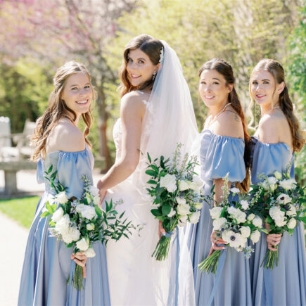 A group of beautiful girls are smiling brightly in the sun, looking forward to a wedding party.