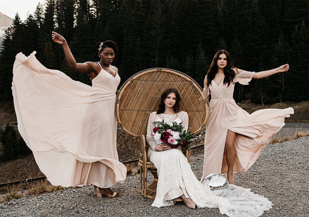 In the forest, a bride receives blessings from her two bridesmaids.