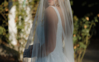 Under the summer sun, a blonde bride smiles for the camera.