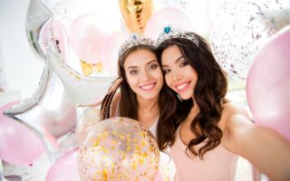 A beautiful bride was taking a selfie with her friend, both smiling happily.