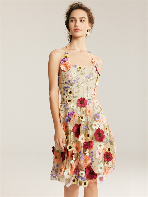 A model in a floral halter dress with colorful embroidered flowers.