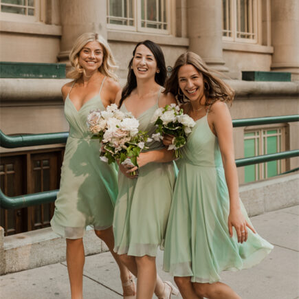 Bridesmaids in light green skirts with bouquets