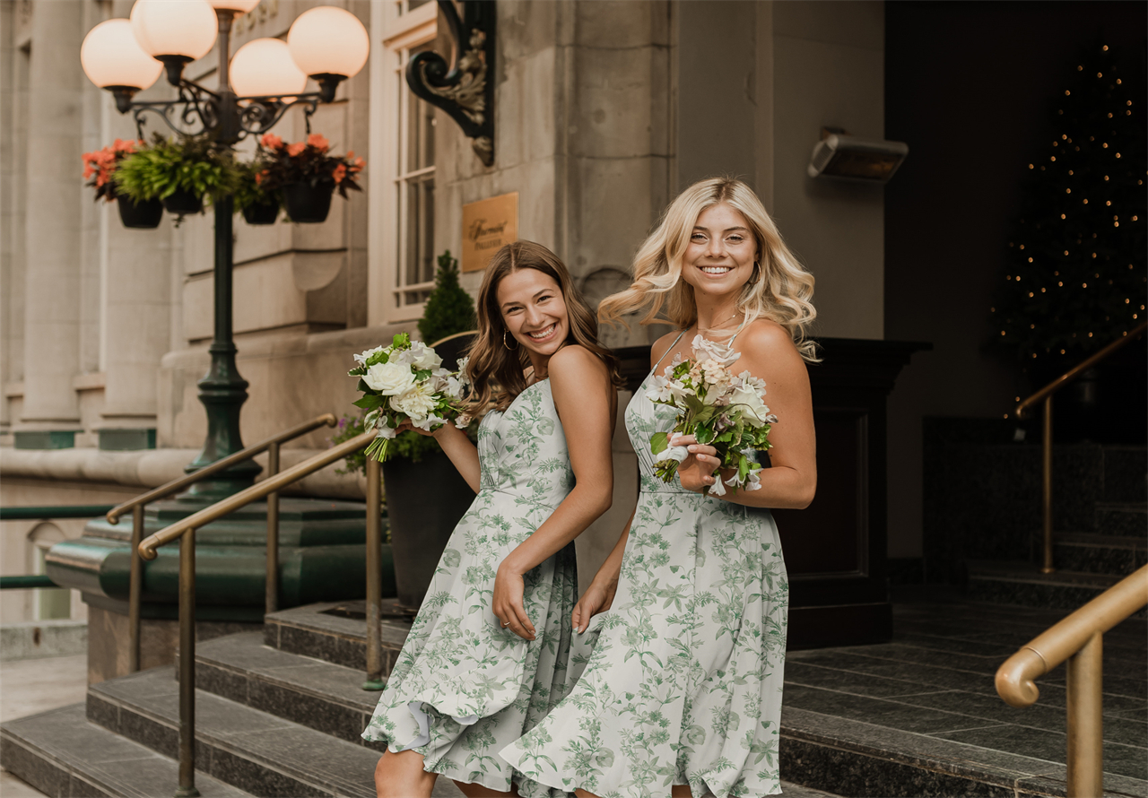 Bridesmaids in green floral dresses, smiling broadly with flowers in their hands.