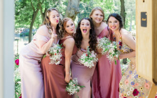 Bridesmaids in colorful dresses posing for a photo.