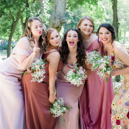 Bridesmaids in colorful dresses posing for a photo.