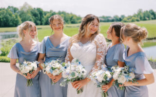 Bride with four bridesmaids in matching light blue dresses.