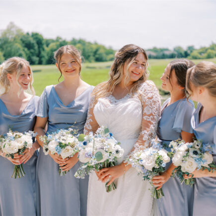 Bride with four bridesmaids in matching light blue dresses.