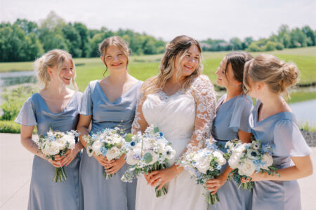 Bride with four bridesmaids in matching light blue dresses.