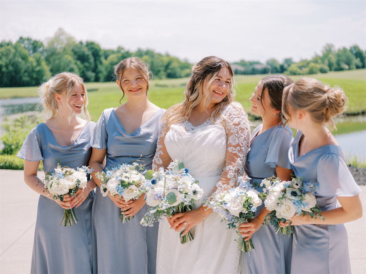 Bride with four bridesmaids in matching light blue dresses.