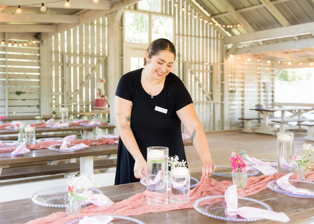 A wedding planner is helping decorate the wedding table.