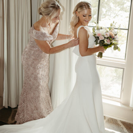 The bride gets ready with the help of loved ones.