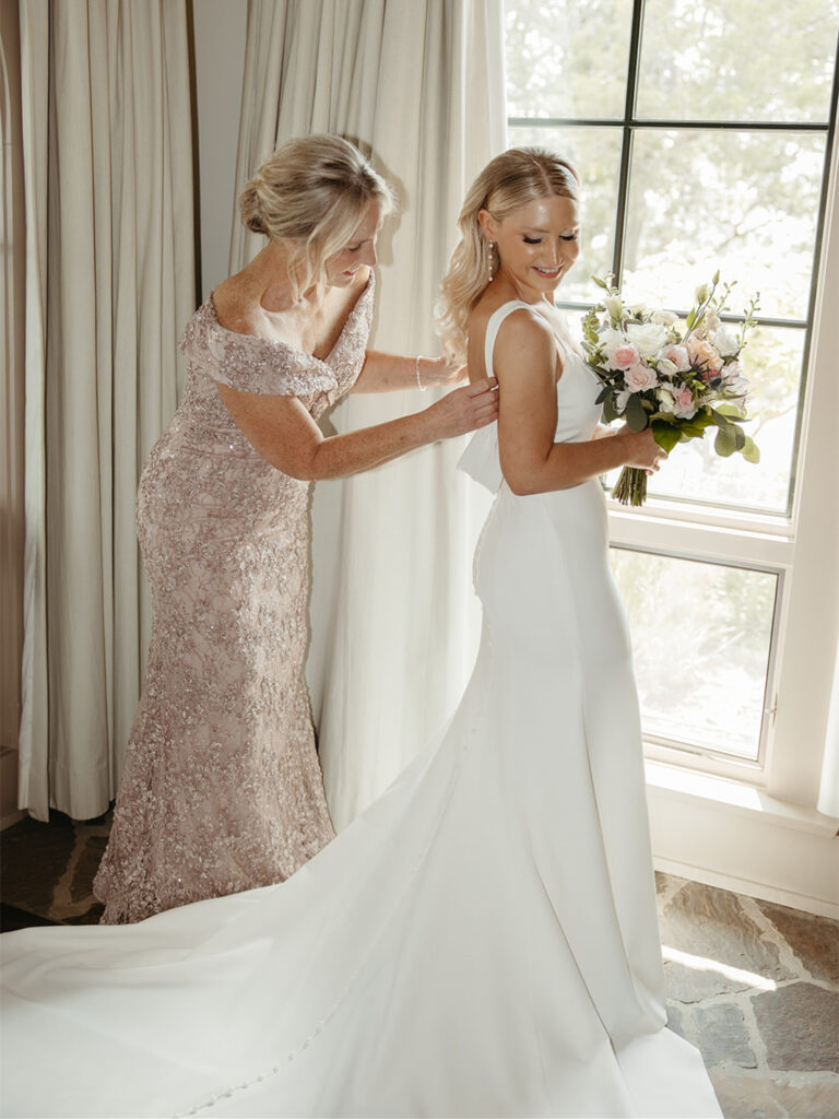 The bride gets ready with the help of loved ones.